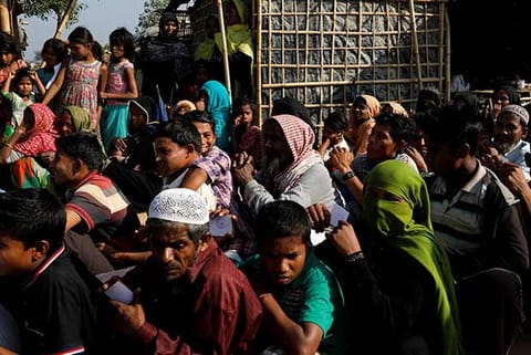 Rohingya refugees wait in line for aid at Kutupalong refugee camp
