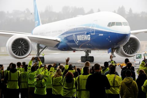Boeing employees and others celebrate as a Boeing 777X airplane returns to a hangar after its first test flight at the company's facility in Seattle, Washington.