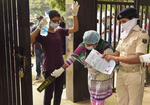 Candidates undergo a security check before entering an examination centre for the National Eligibility-Cum-Entrance Test (NEET), during unlock 4.0, in Patna.