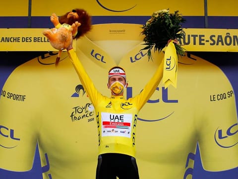 Stage winner Team UAE Emirates rider Slovenia's Tadej Pogacar celebrates his overall leader yellow jersey on the podium after winning the 20th stage of the 107th edition of the Tour de France cycling race, a time trial of 36 km between Lure and La Planche des Belles Filles.