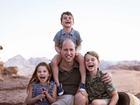 A handout picture released by Kensington Palace on June 18, 2022 shows Britain's Prince William, Duke of Cambridge, (C) posing for a photograph with his children, Britain's Prince Louis of Cambridge (top), Britain's Princess Charlotte of Cambridge (L) and Britain's Prince George of Cambridge (R), taken in Jordan in Autumn, 2021, released to mark Father's Day 2022.