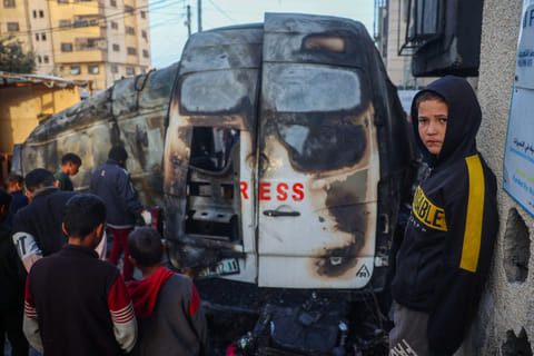 Children check the site of an Israeli strike on a broadcast truck, in the Nuseirat refugee camp in the central Gaza Strip, on December 26, 2024.