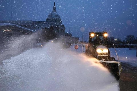 Crews work before dawn to clear snow East Front Plaza of the U.S. Capitol as a winter storm slams into the nation's capital on January 06, 2025 in Washington, DC