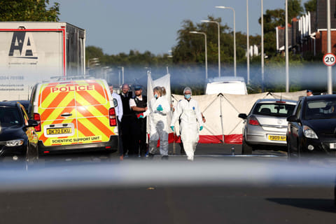 Police officers and forensic personnel put up a fence on Hart Street in Southport, northwest England, on July 29, 2024, following a knife attack.