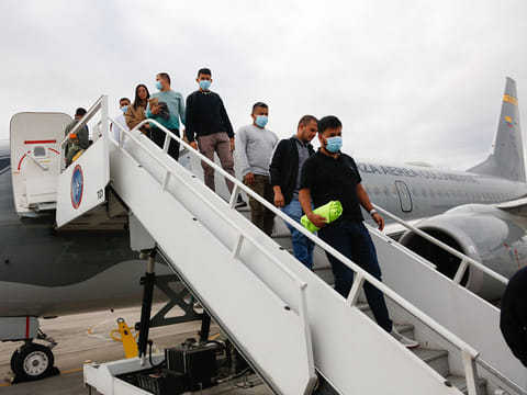Handout picture released by Colombian Foreign Affairs Ministry press office, shows migrants descending from a Colombian Air Force plane after being deported from the US in Bogota on January 28, 2025.