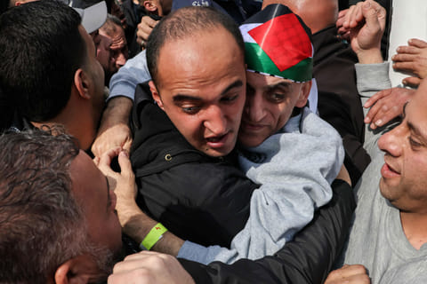A former Palestinian prisoner released by Israel is is hugged by a relative upon his arrival in Ramallah on buses of the International Committee of the Red Cross (ICRC) on February 1, 2025.