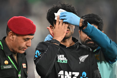New Zealand's Rachin Ravindra (C) receives medical attention after being hit on the head by the ball during the Tri-Nation's first one-day international cricket match between Pakistan and New Zealand at the Gaddafi Stadium in Lahore on February 8, 2025.