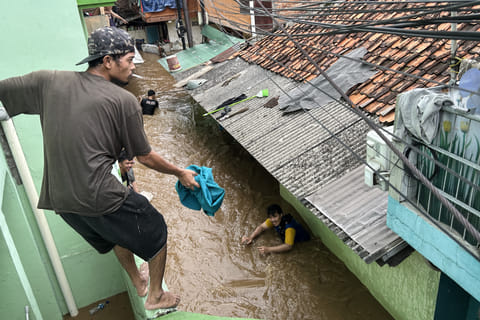 Residents look to evacuate during severe flooding in Jatinegara district in Jakarta.