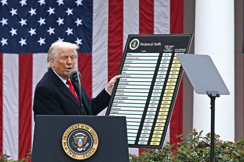 US President Donald Trump delivers remarks on reciprocal tariffs as US Secretary of Commerce Howard Lutnick holds a chart during an event in the Rose Garden entitled "Make America Wealthy Again" at the White House in Washington, DC, on April 2, 2025.