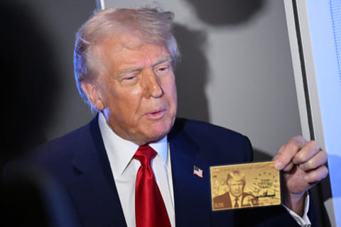 US President Donald Trump holds the $5 million dollar Gold Card as he speaks to reporters while in flight on board Air Force One, en route to Miami, Florida on April 3, 2025.