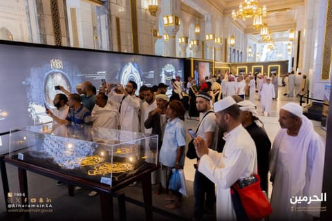 Visitors tour the "First House" exhibit in Mecca.