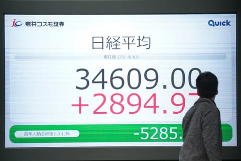 A man looks at an electronic board showing the closing numbers of the Nikkei Stock Average on the Tokyo Stock Exchange in Tokyo on April 10, 2025.
