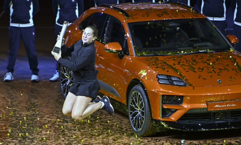 Latvia’s Jelena Ostapenko celebrates with the trophy in front of the winner's car after winning the final match against Belarus’ Aryna Sabalenka at the Women's Tennis Grand Prix WTA tournament in Stuttgart, southwestern Germany, on April 21.