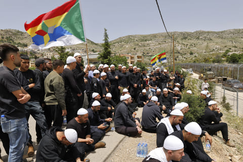 Druze men demonstrate in solidarity with the Syrian Druze community near the border barrier in the village of Majdal Shams in the Israeli-annexed Golan Heights on April 30, 2025.