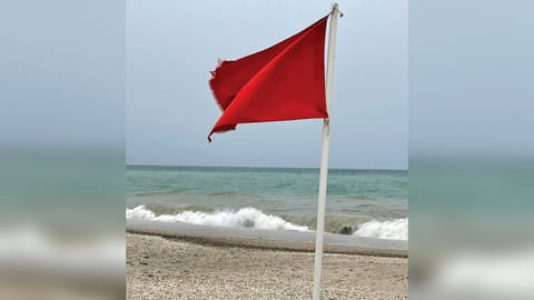 A red flag indicates that Al Zubarah Beach is temporarily closed for swimmers.
