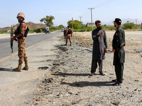 Security personnel stand guard at the site of a school bus bombing in Khuzdar district of Balochistan province on May 21, 2025.