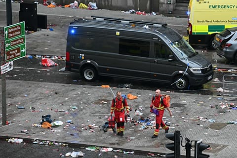 Members of the emergency services are pictured on the scene of the crash in Water Street, on the sidelines of an open-top bus victory parade for Liverpool's Premier League title win on Monday..
