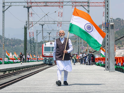 India's Prime Minister Narendra Modi holding national flag during the inauguration of the Chenab Rail Bridge as a part of the Kashmir rail link, in Reasi, in Jammu and Kashmir.