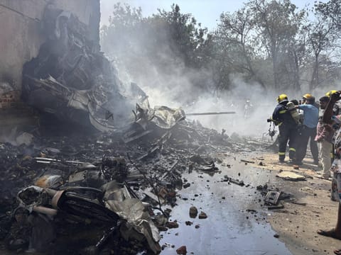 Firefighters work at the site where an Air India airplane crashed in Ahmedabad.