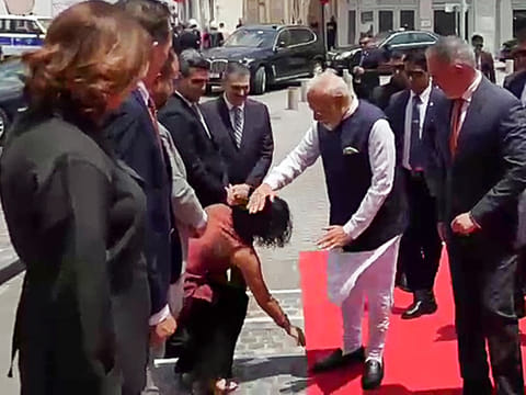 Member of the Council of Nicosia, Michaela Kythreoti Mhlapa, touches the feet of Prime Minister Narendra Modi as a mark of respect while welcoming him at the Historic Centre of Nicosia, in Nicosia on Monday.
