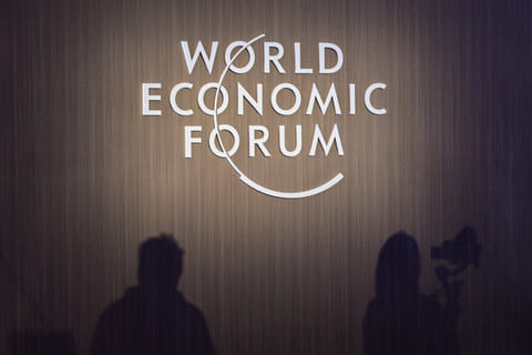 Shadows of journalists are seen beside WEF signage during a session at the World Economic Forum Annual Meeting of the New Champions 2025 (AMNC25) in Tianjin on June 24, 2025.