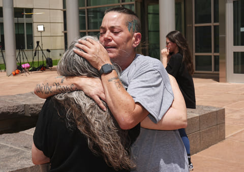 Crystina Page, right, hugs Beth Mosley, who both had retained the services of a Colorado funeral home owner who stashed nearly 190 decomposing bodies.