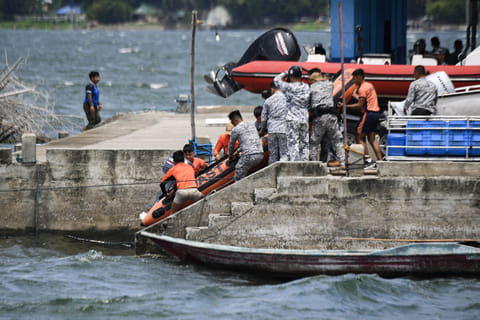 Philippine coast guard personnel prepare to depart to the site where the bodies of cockfighters were allegedly dumped, in Lake Taal off Talisay town, Batangas province, South of Manila on July 10, 2025.
