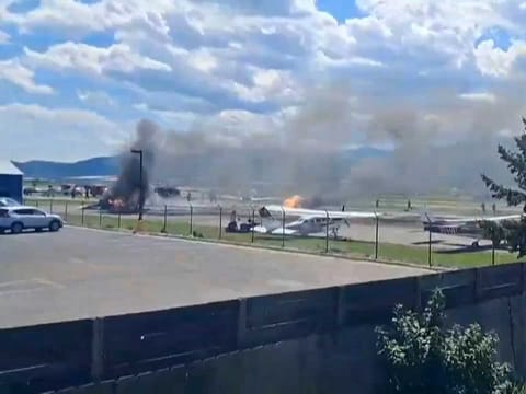 A plane crashes into a parked aircraft at Kalispell City Airport, triggering a large fire, in Kalispell, Montana.