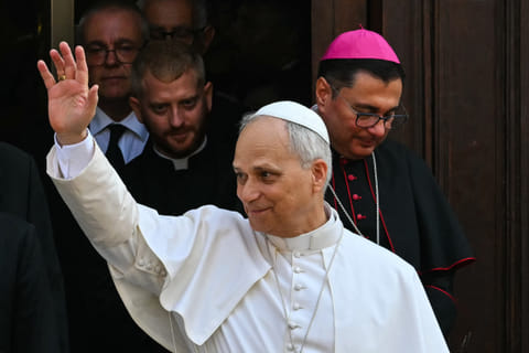 Pope Leo XIV waves to the crowd as he exits the Parrocchia Pontificia di San Tommaso da Villanova (Papal Parish of St. Thomas of Villanova) after leading the Assumption Day Mass at the summer papal estate in Castel Gandolfo, southeast of Rome on August 15, 2025.