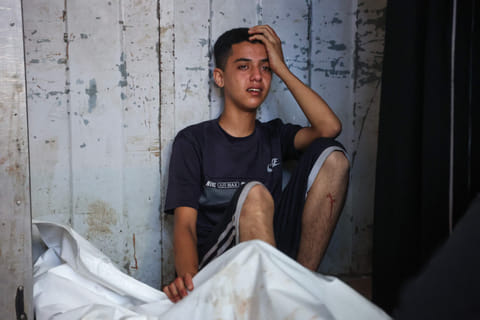A Palestinian youth mourns by the body of a relative killed in Israeli strikes on Gaza City at dawn, at the Al-Shifa hospital on September 2, 2025.