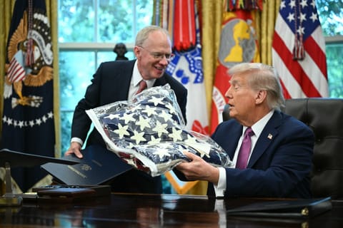 US President Donald Trump (R) receives a flag from US Representative John Rose, Republican of Tennessee, while signing executive orders in the Oval Office of the White House in Washington, DC on September 5, 2025.