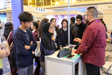 High school students discussing education opportunities with university representatives at Edufair Abu Dhabi