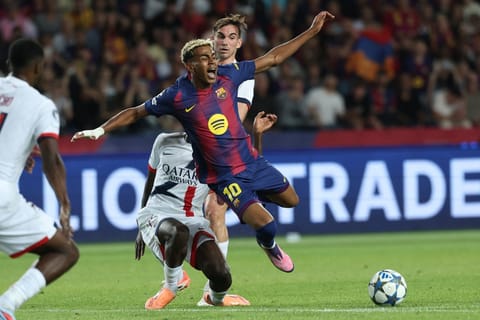 Barcelona's Spanish forward #10 Lamine Yamal (C) reacts as he is fouled by Paris Saint-Germain's Portuguese defender #25 Nuno Mendes during the UEFA Champions League league phase day 2 football match between FC Barcelona and Paris Saint-Germain (PSG) at the Estadi Olimpic Lluis Companys in Barcelona, on October 1, 2025.
