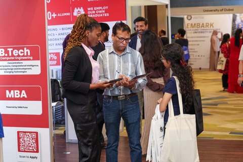 Families discussing education opportunities with exhibitors at Edufair