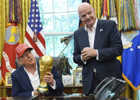 President Donald Trump holds the FIFA World Cup Winners Trophy as FIFA President Gianni Infantino looks on during an announcement in the Oval Office of the White House, Aug. 22, 2025, in Washington.
