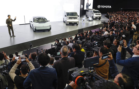 Toyota's President and CEO Koji Sato, left, speaks to the media beside Toyota vehicles on display at Tokyo Mobility Show during a press day at Tokyo Big Sight in Tokyo, on Wednesday, Oct. 29, 2025.