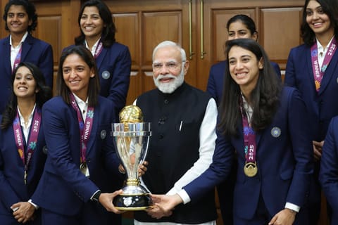 Prime Minister Narendra Modi holding the trophy poses for a group picture with the champions of the Women’s World Cup 2025, at his residence 7, LKM in New Delhi on Wednesday.