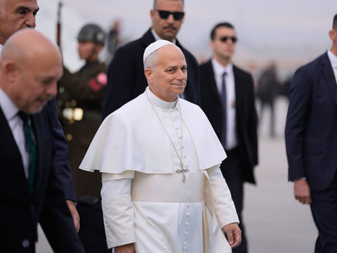 Pope Leo XIV is escorted by security members upon his arrival at Esenboga International Airport in Ankara, Turkey, Thursday, Nov. 27, 2025, marking the beginning of his first foreign trip.