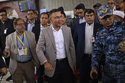 This handout photograph from the official Facebook page of the Bangladesh Nationalist Party (BNP) Media Cell taken and released on December 25, 2025 shows acting chairman of the Bangladesh Nationalist Party (BNP), Tarique Rahman (C) walking upon his arrival in Dhaka.