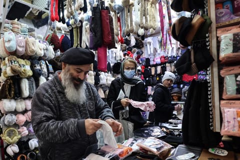 A shopkeeper tidies his stall in Tajrish Bazaar in the Iranian capital Tehran on December 29, 2025.