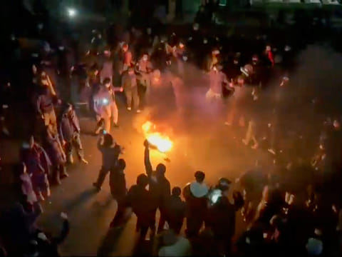 In this frame grab from footage circulating on social media shows protesters dancing and cheering around a bonfire as they take to the streets in Tehran, Iran.