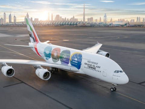 The livery showcases a melange of tennis-inspired elements, with each Grand Slam logo framed within a tennis ball emblem and rendered in the tournament's signature colours.