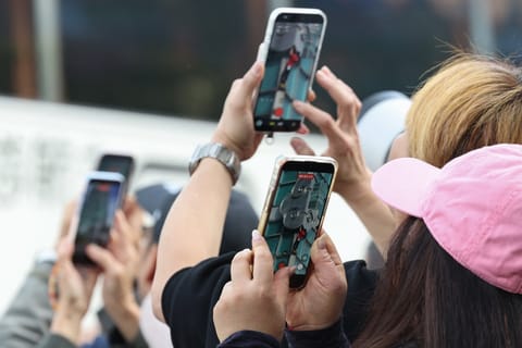 Onlookers use their phones to record footage