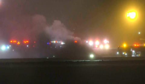 This image taken from video provided by WABI television, emergency services work on a scene of the Bombardier Challenger 600 crash at the Bangor Airport in Maine, late Sunday, Jan. 25, 2026. (WABI via AP)