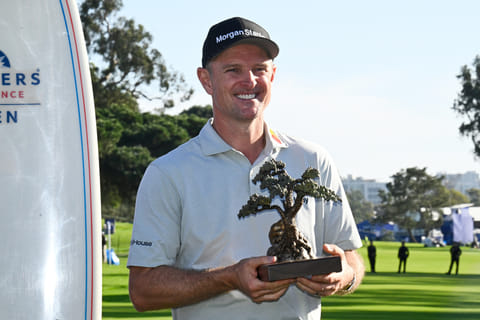 Justin Rose, of England, holds the winner's trophy at the Farmers Insurance Open golf tournament Sunday, Feb. 1, 2026, at Torrey Pines in San Diego.