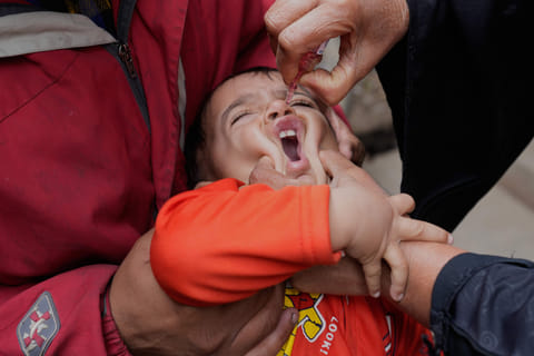 A health worker administers a polio vaccine to a child at a neighbourhood in Lahore, Pakistan, Monday, Feb. 2, 2026.
