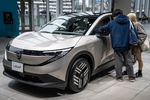 People look at a car on display at a showroom of Japanese automaker Nissan Motor in Yokohama, Kanagawa prefecture on February 11, 2026.