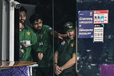 Pakistan's Babar Azam (C) and his captain Salman Agha (L) react after the 2026 ICC Men's T20 Cricket World Cup Super Eight match between Pakistan and New Zealand was called off due to rain at the R Premadasa Stadium in Colombo on February 21, 2026.
