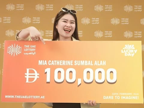 A life-changing first try: Mia Catherine Sumbal Alah proudly displays her Dh100,000 winnings from the UAE Lottery draw.