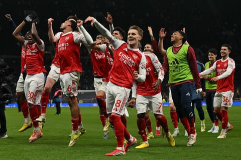 Arsenal celebrate their victory against Spurs with their travelling fans